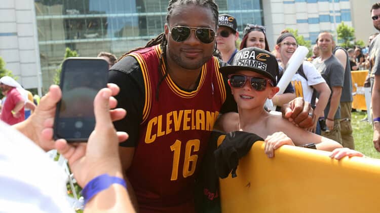 Former member of the Cleveland Browns Josh Cribbs poses with a fan during the Cleveland Cavaliers 2016 NBA Championship victory parade and rally on June 22, 2016 in Cleveland, Ohio.