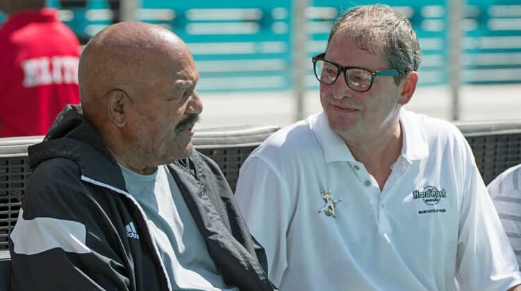 Former Cleveland Browns quarterback Bernie Kosar talks with Hall of Fame running back Jim Brown before the start of the game against the Miami Dolphins on September 25, 2016 in Miami Gardens, Florida.