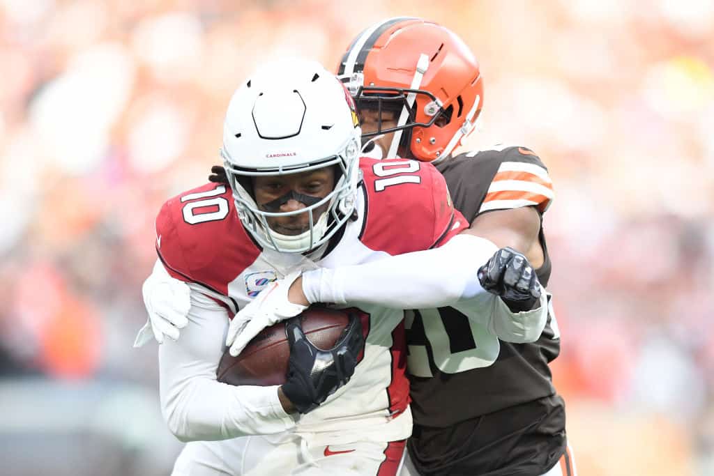 Greg Newsome II #20 of the Cleveland Browns tackles DeAndre Hopkins #10 of the Arizona Cardinals after a catch during the second quarter at FirstEnergy Stadium on October 17, 2021 in Cleveland, Ohio.