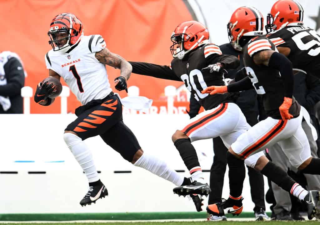 Ja'Marr Chase #1 of the Cincinnati Bengals runs the ball as Greg Newsome II #20 of the Cleveland Browns attempts to make the tackle during the first half at FirstEnergy Stadium on January 09, 2022 in Cleveland, Ohio.