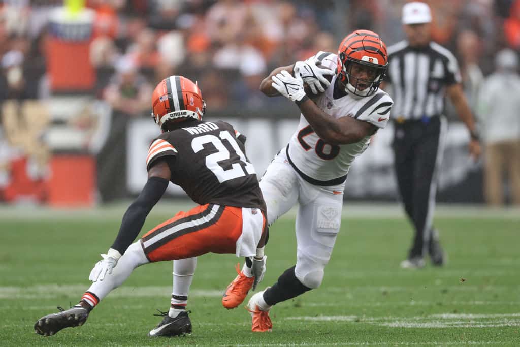 Joe Mixon #28 of the Cincinnati Bengals runs the ball against Denzel Ward #21 of the Cleveland Browns during the second half at Cleveland Browns Stadium on September 10, 2023 in Cleveland, Ohio.
