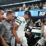Quarterback Aaron Rodgers #8 of the New York Jets is helped off the field after an injury during the first quarter of the NFL game against the Buffalo Bills at MetLife Stadium on September 11, 2023 in East Rutherford, New Jersey.