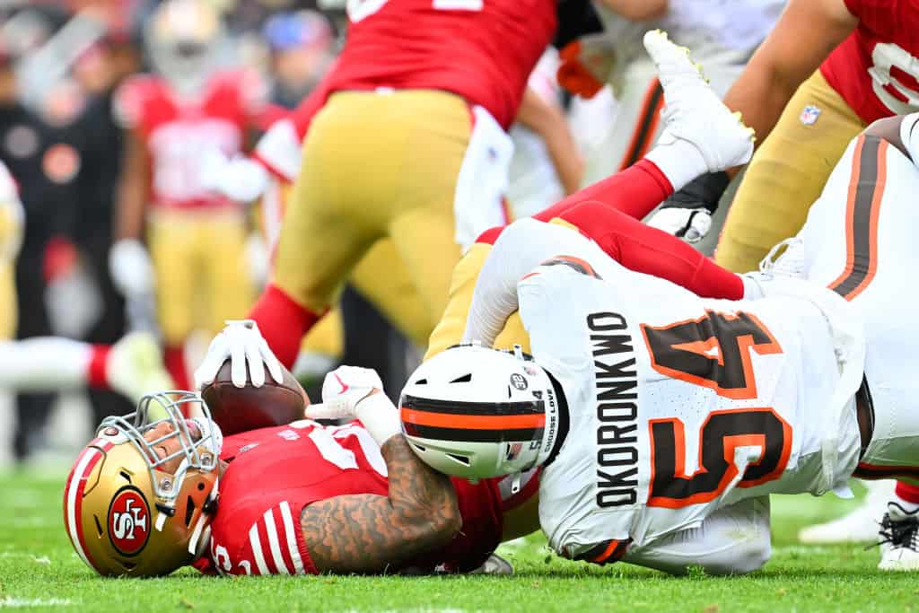 Ogbo Okoronkwo #54 of the Cleveland Browns tackles Elijah Mitchell #25 of the San Francisco 49ers during the third quarter at Cleveland Browns Stadium on October 15, 2023 in Cleveland, Ohio.