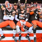 Ronnie Hickman #33, Martin Emerson Jr. #23, and Greg Newsome II #0 of the Cleveland Browns celebrate with fans after beating the Pittsburgh Steelers 13-10 at Cleveland Browns Stadium on November 19, 2023 in Cleveland, Ohio.