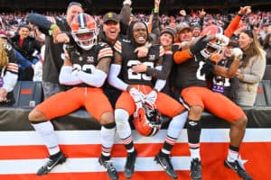 Ronnie Hickman #33, Martin Emerson Jr. #23, and Greg Newsome II #0 of the Cleveland Browns celebrate with fans after beating the Pittsburgh Steelers 13-10 at Cleveland Browns Stadium on November 19, 2023 in Cleveland, Ohio.