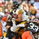 Jaylen Warren #30 of the Pittsburgh Steelers runs with the ball while being tackled by Jeremiah Owusu-Koramoah #6 and Ronnie Hickman #33 of the Cleveland Browns in the third quarter at Cleveland Browns Stadium on November 19, 2023 in Cleveland, Ohio.