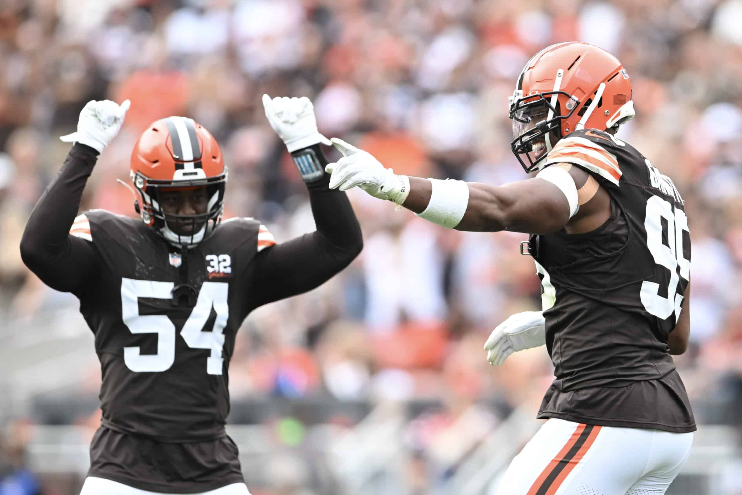 Ogbo Okoronkwo #54 and Myles Garrett #95 of the Cleveland Browns celebrate a play during the first half in the game against the Tennessee Titans at Cleveland Browns Stadium on September 24, 2023 in Cleveland, Ohio.