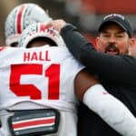 Head coach Ryan Day of the Ohio State Buckeyes hugs defensive tackle Michael Hall Jr. #51 before a college football game against the Rutgers Scarlet Knights at SHI Stadium on November 4, 2023 in Piscataway, New Jersey.
