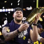 Zak Zinter #65 of the Michigan Wolverines holds the national championship trophy after defeating the Washington Huskies during the 2024 CFP National Championship game at NRG Stadium on January 08, 2024 in Houston, Texas. Michigan defeated Washington 34-13.