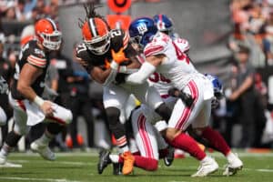 CLEVELAND, OHIO - SEPTEMBER 22: D'Onta Foreman #27 of the Cleveland Browns is hit by Micah McFadden #41 of the New York Giants during the first quarter at Cleveland Browns Stadium on September 22, 2024 in Cleveland, Ohio.