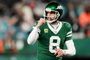 EAST RUTHERFORD, NEW JERSEY - JANUARY 05: Aaron Rodgers #8 of the New York Jets reacts after a touchdown against the Miami Dolphins during the fourth quarter at MetLife Stadium on January 05, 2025 in East Rutherford, New Jersey.