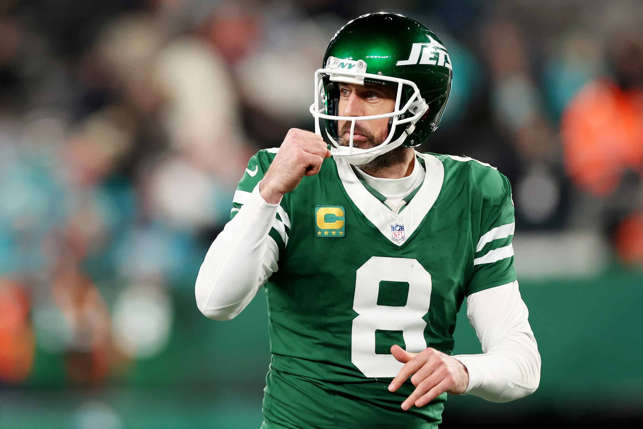 EAST RUTHERFORD, NEW JERSEY - JANUARY 05: Aaron Rodgers #8 of the New York Jets reacts after a touchdown against the Miami Dolphins during the fourth quarter at MetLife Stadium on January 05, 2025 in East Rutherford, New Jersey.