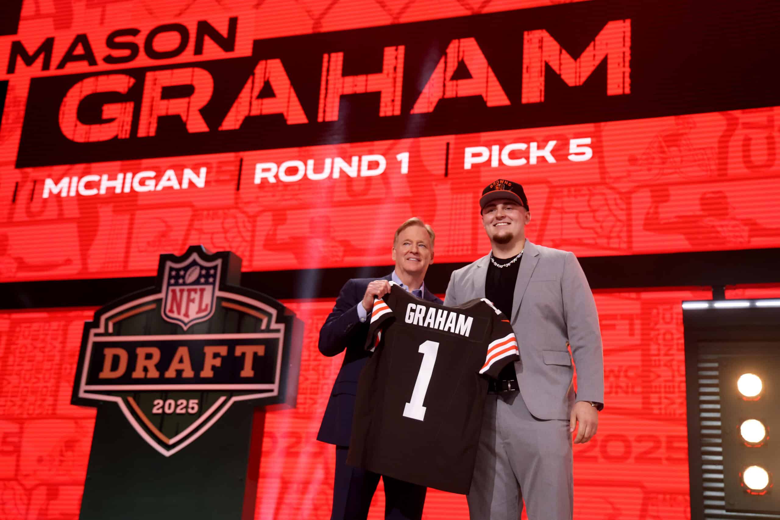 GREEN BAY, WISCONSIN - APRIL 24: Defensive Tackle Mason Graham of Michigan poses with NFL Commissioner Roger Goodell after being selected fifth overall pick by the Cleveland Browns during the first round of the 2025 NFL Draft at Lambeau Field on April 24, 2025 in Green Bay, Wisconsin.