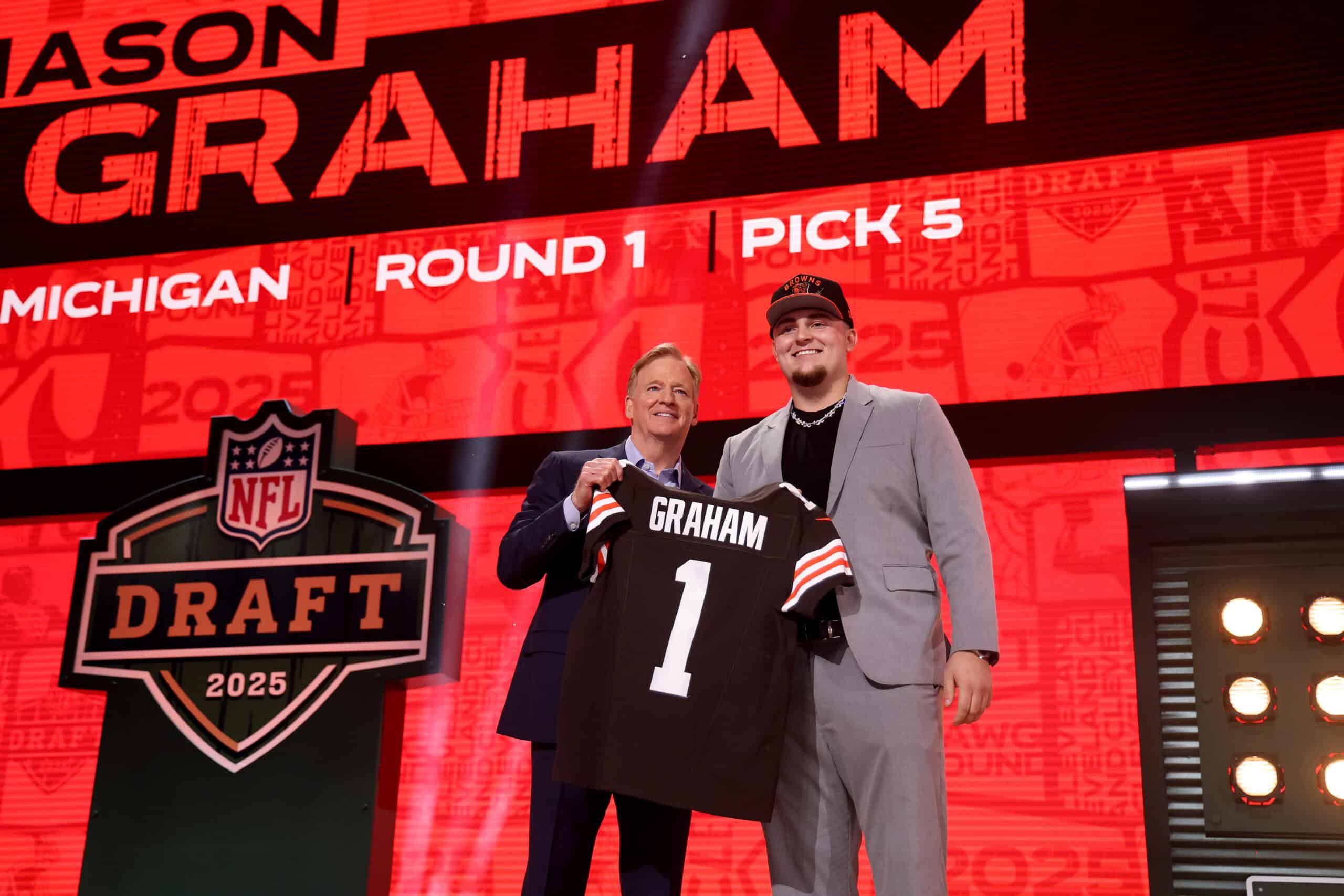 GREEN BAY, WISCONSIN - APRIL 24: Defensive Tackle Mason Graham of Michigan poses with NFL Commissioner Roger Goodell after being selected fifth overall pick by the Cleveland Browns during the first round of the 2025 NFL Draft at Lambeau Field on April 24, 2025 in Green Bay, Wisconsin.
