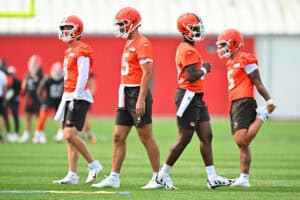 BEREA, OHIO - JUNE 12: Quarterbacks Kenny Pickett #8 Joe Flacco #15 Shedeur Sanders #12 Dillon Gabriel #5 of the Cleveland Browns warm up before organized team activities at CrossCountry Mortgage Campus on June 12, 2025 in Berea, Ohio.