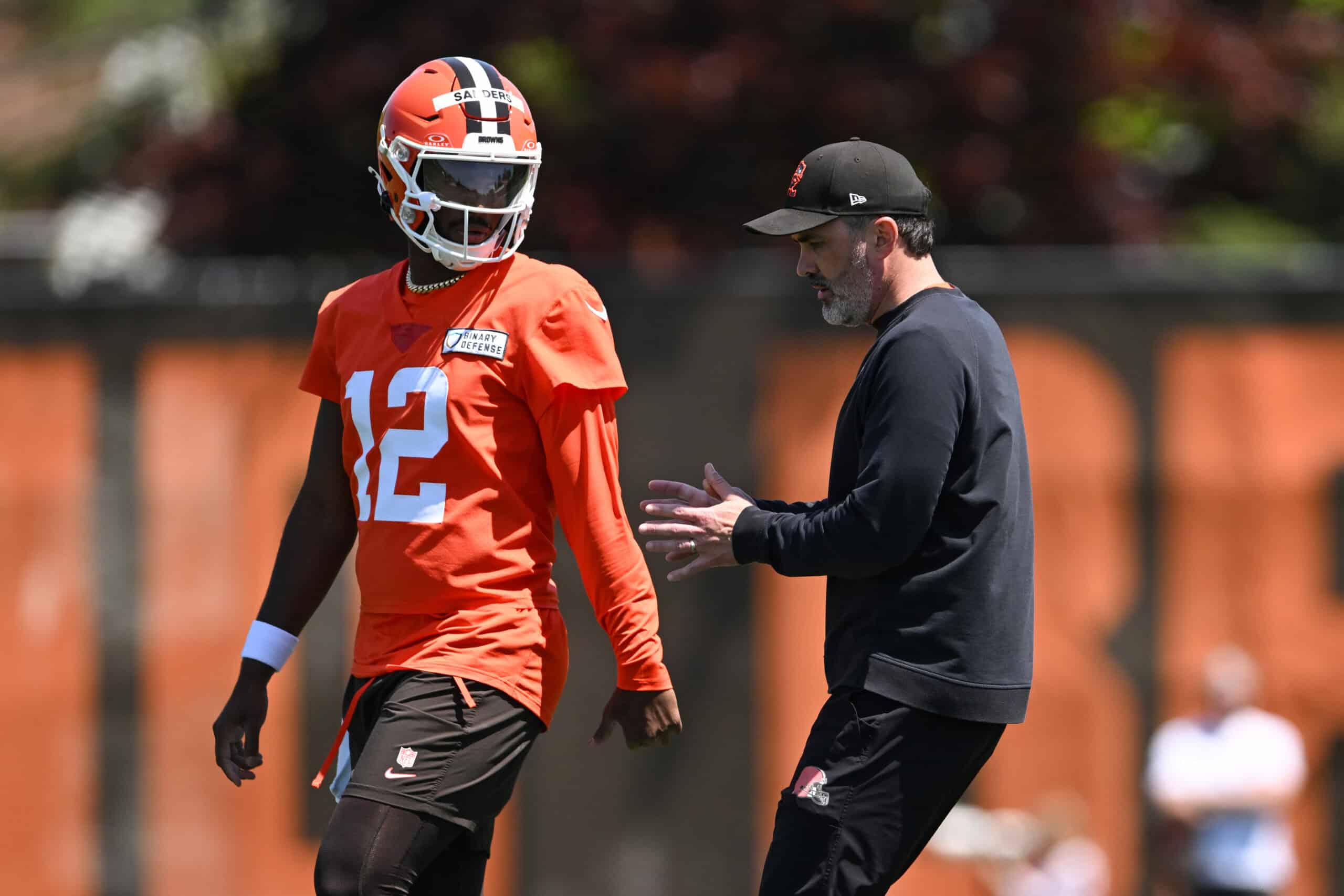 BEREA, OHIO - MAY 10: Head coach Kevin Stefanski of the Cleveland Browns instructs Shedeur Sanders #12 during rookie minicamp at CrossCountry Mortgage Campus on May 10, 2025 in Berea, Ohio.