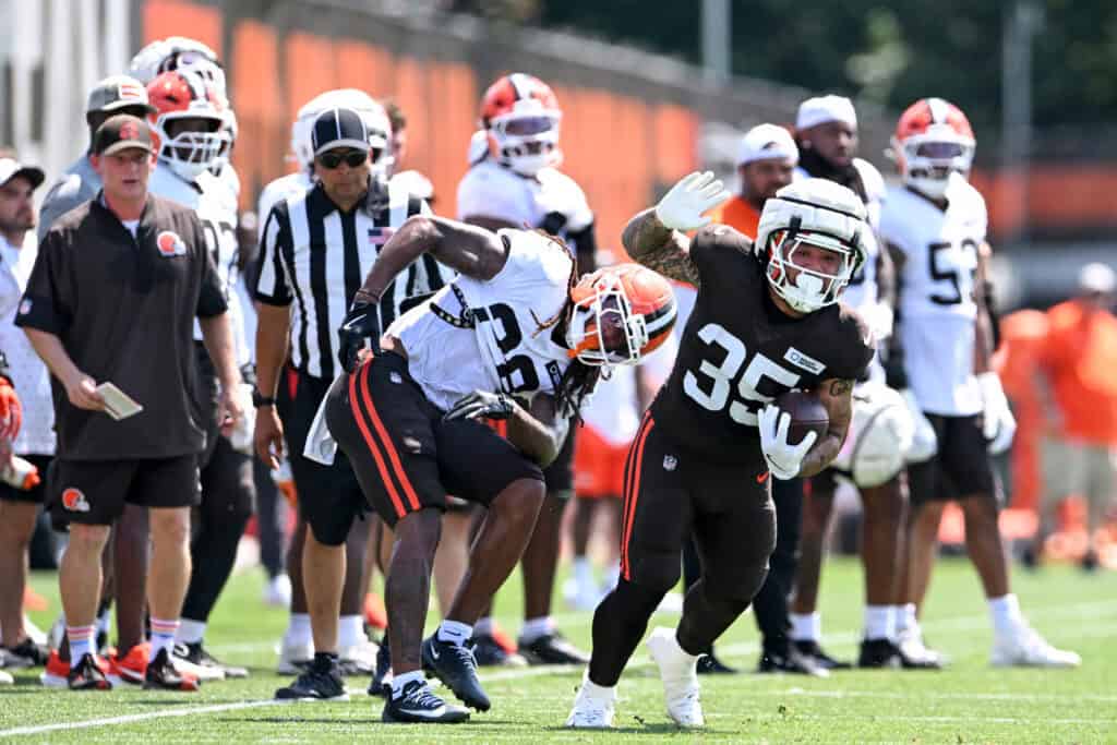BEREA, OHIO - JULY 28: Toa Taua #35 of the Cleveland Browns breaks a tackle by Rayshawn Jenkins #28 during Cleveland Browns training camp at CrossCountry Mortgage Campus on July 28, 2025 in Berea, Ohio.