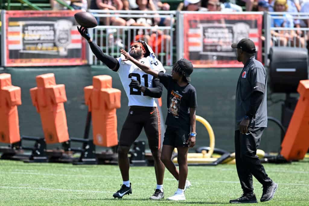 BEREA, OHIO - JULY 28: Denzel Ward #21 of the Cleveland Browns catches a pass against a fan during Cleveland Browns training camp at CrossCountry Mortgage Campus on July 28, 2025 in Berea, Ohio.