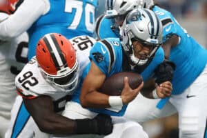 CHARLOTTE, NORTH CAROLINA - AUGUST 08: Quarterback Bryce Young #9 of the Carolina Panthers is tackled by defensive end Sam Kamara #92 of the Cleveland Browns in the first half during the NFL Preseason 2025 game at Bank of America Stadium on August 08, 2025 in Charlotte, North Carolina.