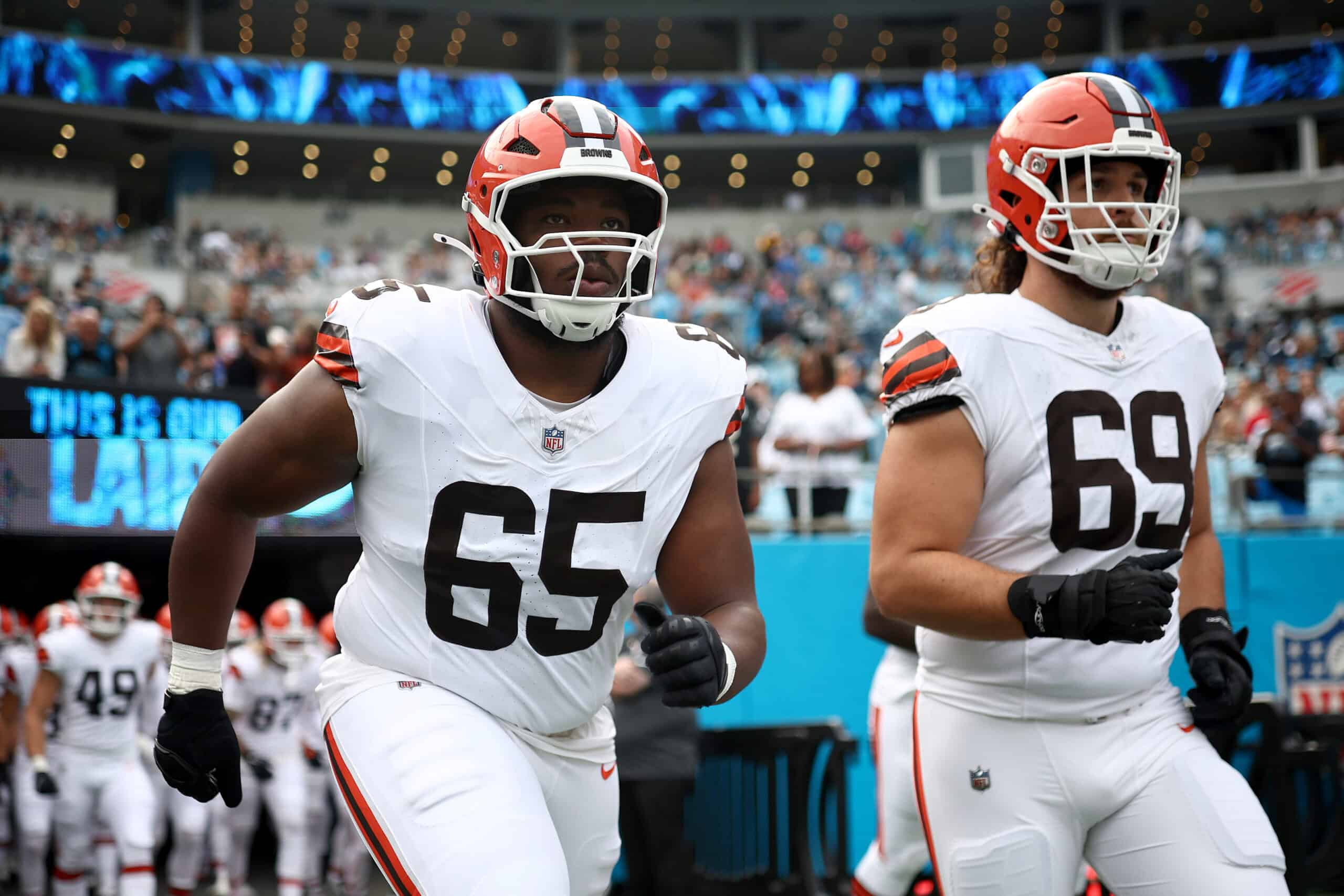 CHARLOTTE, NORTH CAROLINA - AUGUST 08: Guard Dartanyan Tinsley #65 and offensive tackle Lorenzo Thompson #69 of the Cleveland Browns run onto the field prior to the NFL Preseason 2025 game at Bank of America Stadium on August 08, 2025 in Charlotte, North Carolina.