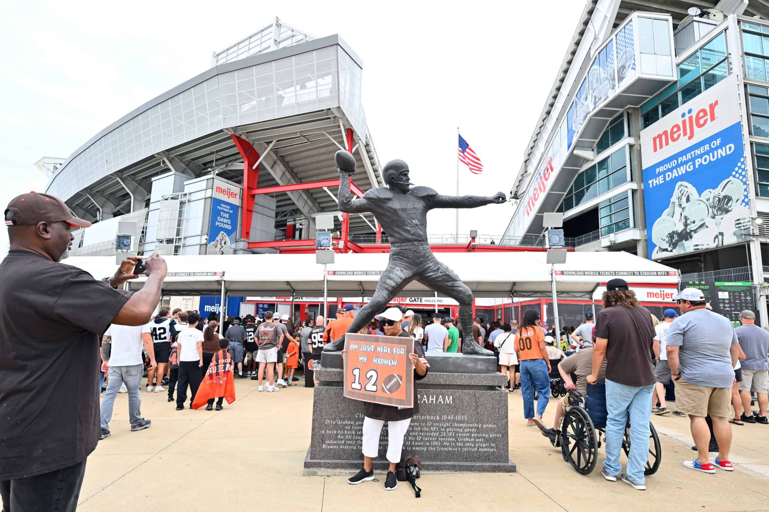 CLEVELAND, OHIO - AUGUST 23: Fans take a photo with a statue of Otto Graham outside Huntington Bank Field before the NFL Preseason 2025 game between Los Angeles Rams and Cleveland Browns on August 23, 2025 in Cleveland, Ohio.