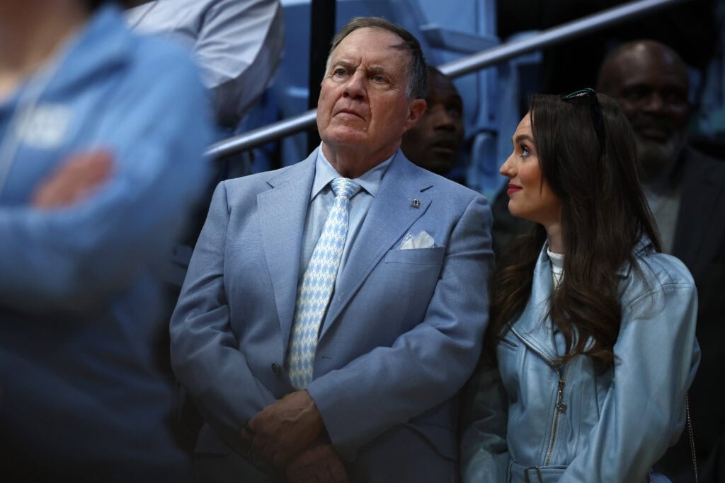 CHAPEL HILL, NORTH CAROLINA - MARCH 08: North Carolina Tar Heels football head coach Bill Belichick and his girlfriend Jordon Hudson look on during the first half of the game between the North Carolina Tar Heels and the Duke Blue Devils at Dean E. Smith Center on March 08, 2025 in Chapel Hill, North Carolina.