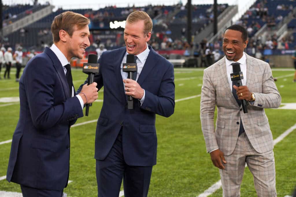 CANTON, OHIO - AUGUST 04: (L to R) NBC Sports commentators Jac Collinsworth, Chris Simms and Rodney Harrison laugh during a segment prior to the 2022 Pro Hall of Fame Game between the Jacksonville Jaguars and the Las Vegas Raiders at Tom Benson Hall of Fame Stadium on August 04, 2022 in Canton, Ohio.