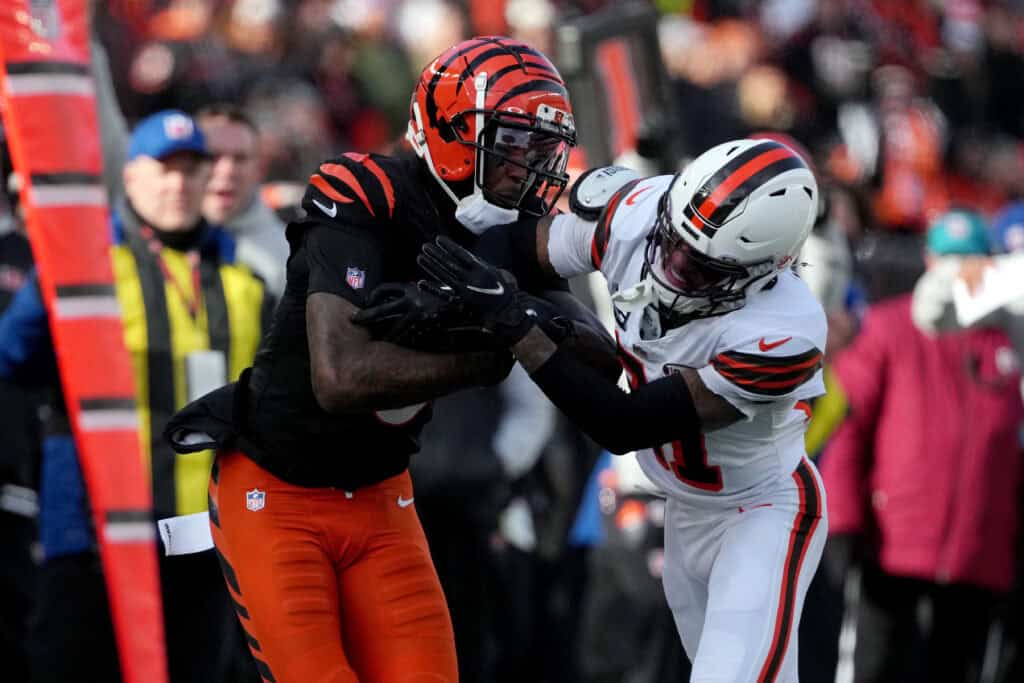 CINCINNATI, OHIO - DECEMBER 22: Tee Higgins #5 of the Cincinnati Bengals is tackled by Denzel Ward #21 of the Cleveland Browns during the first quarter at Paycor Stadium on December 22, 2024 in Cincinnati, Ohio.