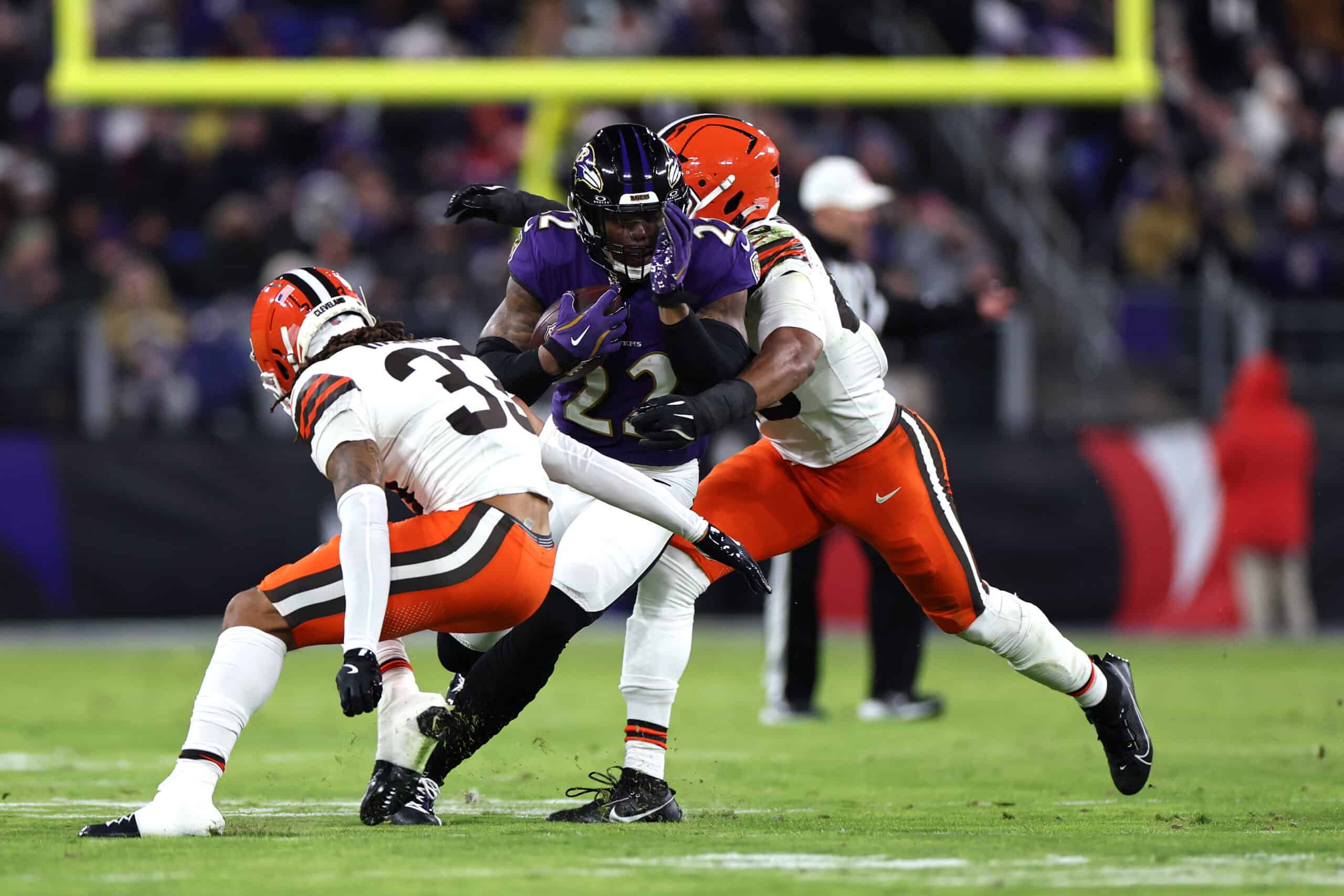BALTIMORE, MARYLAND - JANUARY 04: Derrick Henry #22 of the Baltimore Ravens runs with the ball while defended by Ronnie Hickman #33 of the Cleveland Browns during the second quarter at M&T Bank Stadium on January 04, 2025 in Baltimore, Maryland.