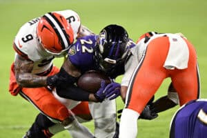 BALTIMORE, MARYLAND - JANUARY 04: Derrick Henry #22 of the Baltimore Ravens is tackled by Grant Delpit #9 of the Cleveland Browns during the third quarter at M&T Bank Stadium on January 04, 2025 in Baltimore, Maryland.