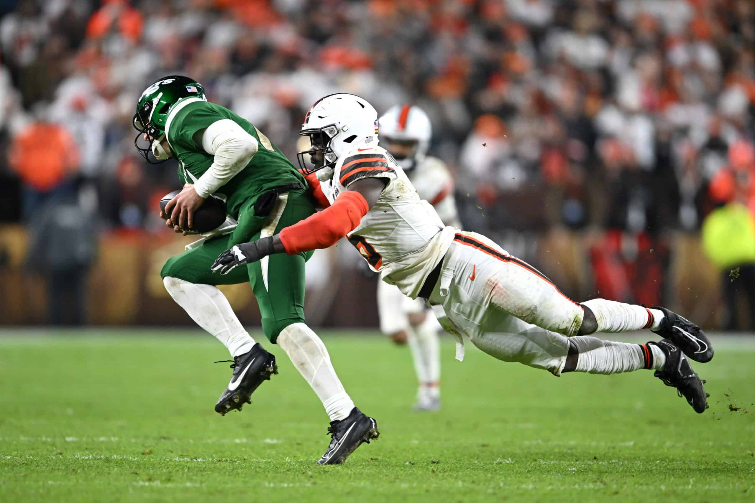 CLEVELAND, OHIO - DECEMBER 28: Jeremiah Owusu-Koramoah #6 of the Cleveland Browns tackles Trevor Siemian #14 of the New York Jets at Cleveland Browns Stadium on December 28, 2023 in Cleveland, Ohio.