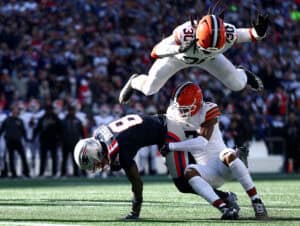 FOXBOROUGH, MASSACHUSETTS - OCTOBER 26: Stefon Diggs #8 of the New England Patriots scores a touchdown defended by Tyson Campbell #7 and Devin Bush #30 of the Cleveland Browns during the third quarter in the game at Gillette Stadium on October 26, 2025 in Foxborough, Massachusetts.