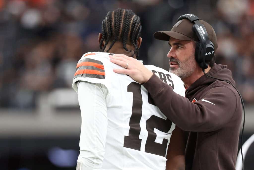 LAS VEGAS, NEVADA - NOVEMBER 23: Head coach Kevin Stefanski talks to Shedeur Sanders #12 of the Cleveland Browns during the first quarter against the Las Vegas Raiders at Allegiant Stadium on November 23, 2025 in Las Vegas, Nevada.
