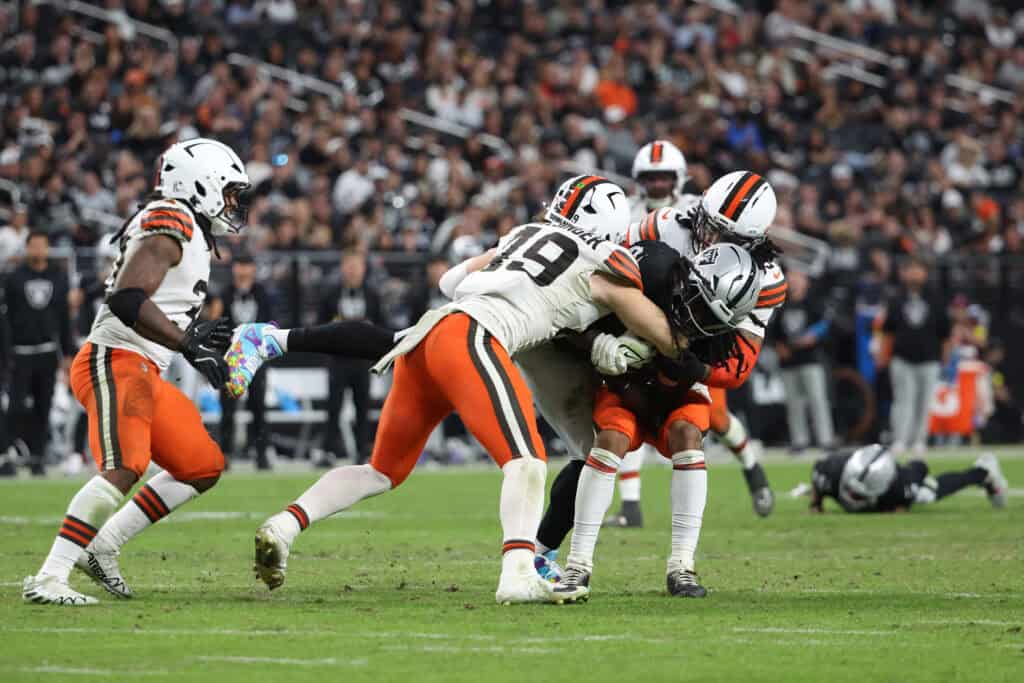 LAS VEGAS, NEVADA - NOVEMBER 23: Ian Thomas #80 of the Las Vegas Raiders is tackled by Carson Schwesinger #49 of the Cleveland Browns in the fourth quarter of a game at Allegiant Stadium on November 23, 2025 in Las Vegas, Nevada.