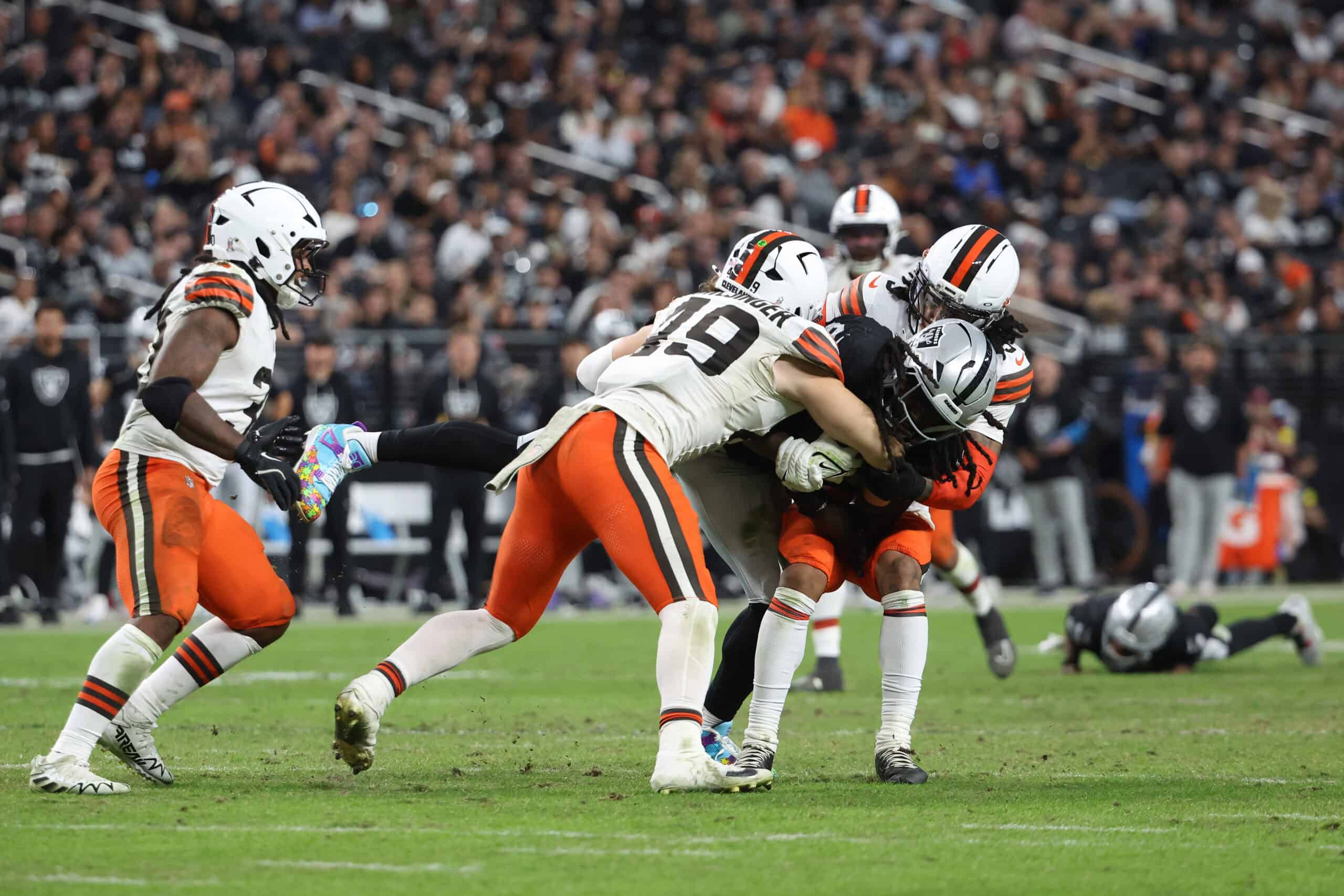 LAS VEGAS, NEVADA - NOVEMBER 23: Ian Thomas #80 of the Las Vegas Raiders is tackled by Carson Schwesinger #49 of the Cleveland Browns in the fourth quarter of a game at Allegiant Stadium on November 23, 2025 in Las Vegas, Nevada.