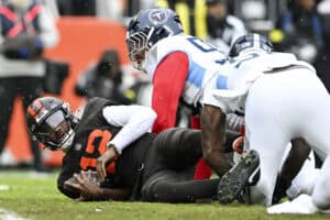 CLEVELAND, OHIO - DECEMBER 07: Shedeur Sanders #12 of the Cleveland Browns is sacked by Jeffery Simmons #98 of the Tennessee Titans during the first quarter at Huntington Bank Field on December 07, 2025 in Cleveland, Ohio.