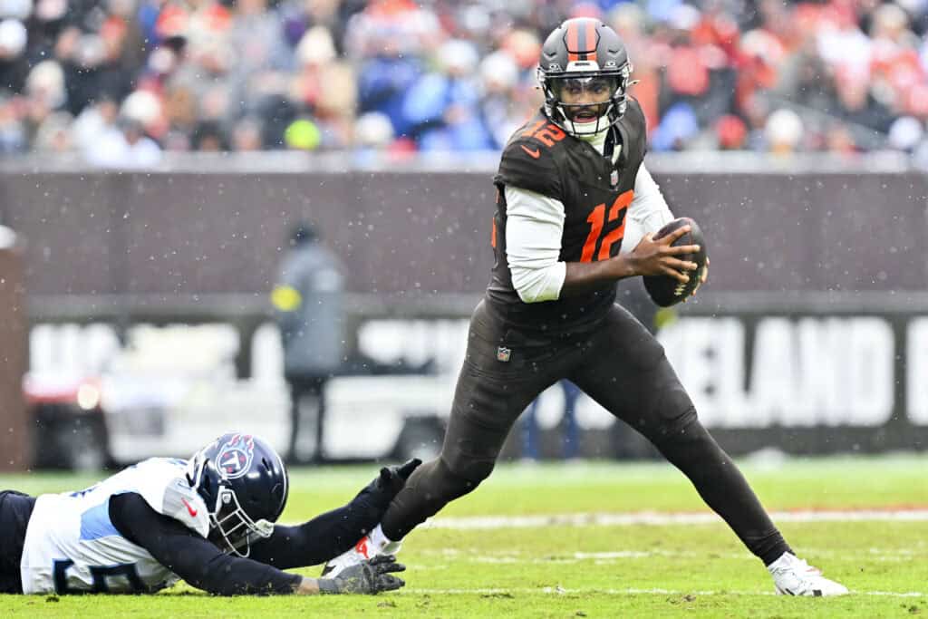 CLEVELAND, OHIO - DECEMBER 07: Jihad Ward #53 of the Tennessee Titans attempts to tackle Shedeur Sanders #12 of the Cleveland Browns during the first quarter at Huntington Bank Field on December 07, 2025 in Cleveland, Ohio.