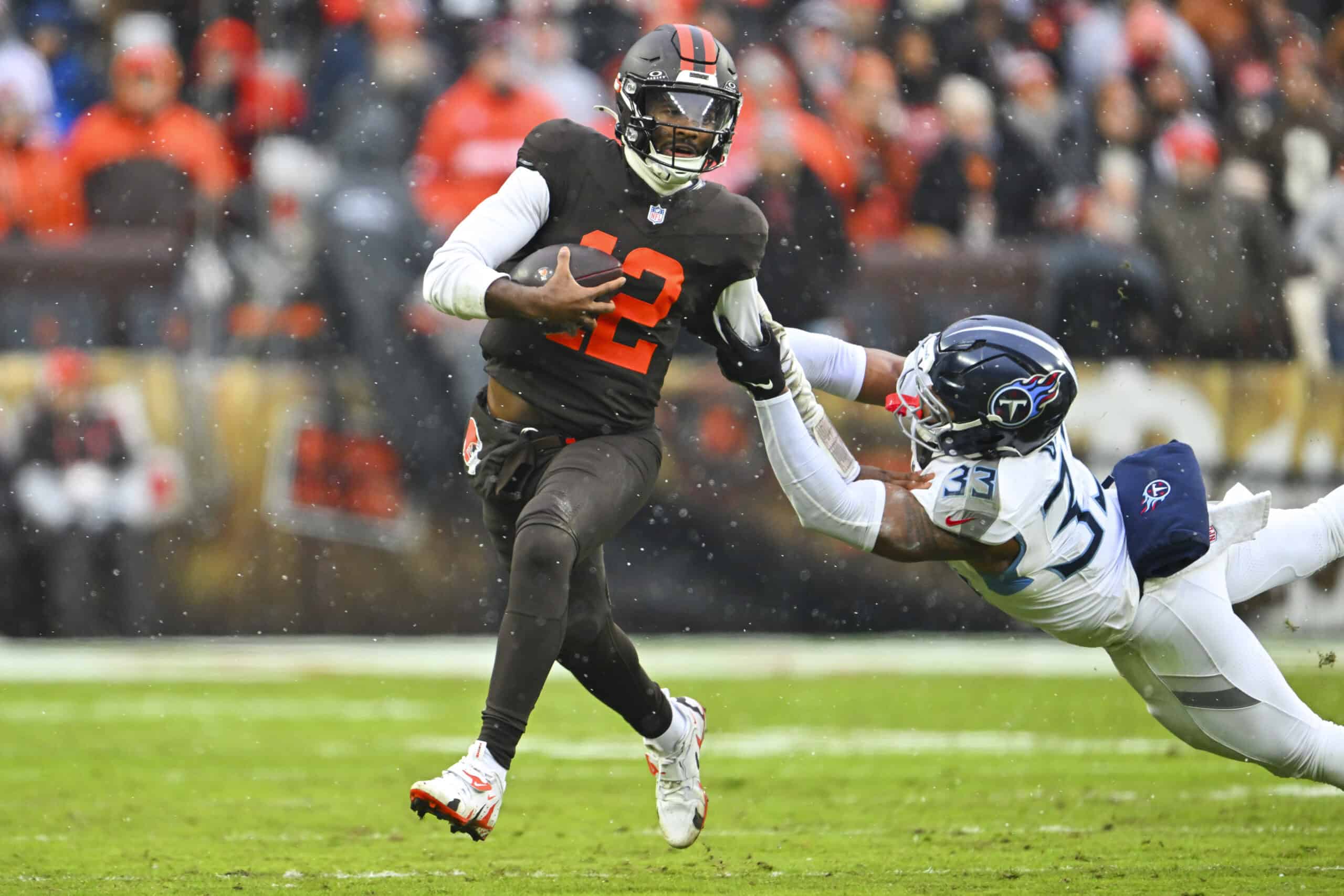 CLEVELAND, OHIO - DECEMBER 07: Shedeur Sanders #12 of the Cleveland Browns is tackled by Cedric Gray #33 of the Tennessee Titans during the second quarter at Huntington Bank Field on December 07, 2025 in Cleveland, Ohio.