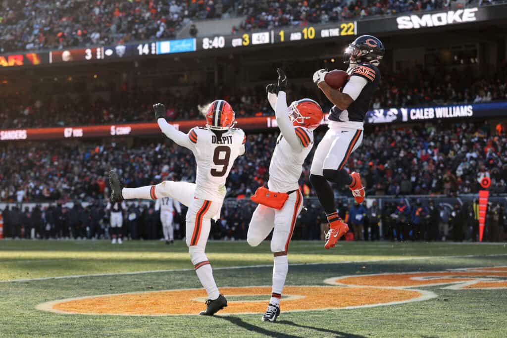CHICAGO, ILLINOIS - DECEMBER 14: D'Marco Jackson #48 of the Chicago Bears pulls down an interception over Grant Delpit #9 and Tyson Campbell #7 of the Cleveland Browns during the third quarter at Soldier Field on December 14, 2025 in Chicago, Illinois.