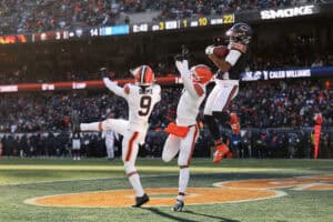 CHICAGO, ILLINOIS - DECEMBER 14: D'Marco Jackson #48 of the Chicago Bears pulls down an interception over Grant Delpit #9 and Tyson Campbell #7 of the Cleveland Browns during the third quarter at Soldier Field on December 14, 2025 in Chicago, Illinois.