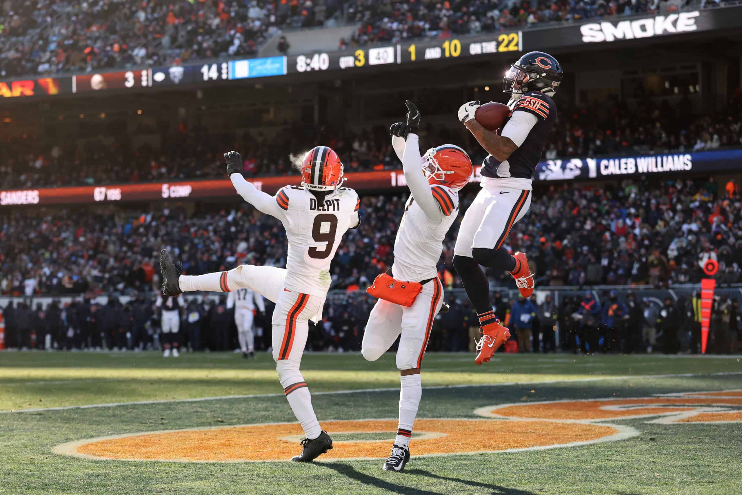 CHICAGO, ILLINOIS - DECEMBER 14: D'Marco Jackson #48 of the Chicago Bears pulls down an interception over Grant Delpit #9 and Tyson Campbell #7 of the Cleveland Browns during the third quarter at Soldier Field on December 14, 2025 in Chicago, Illinois.