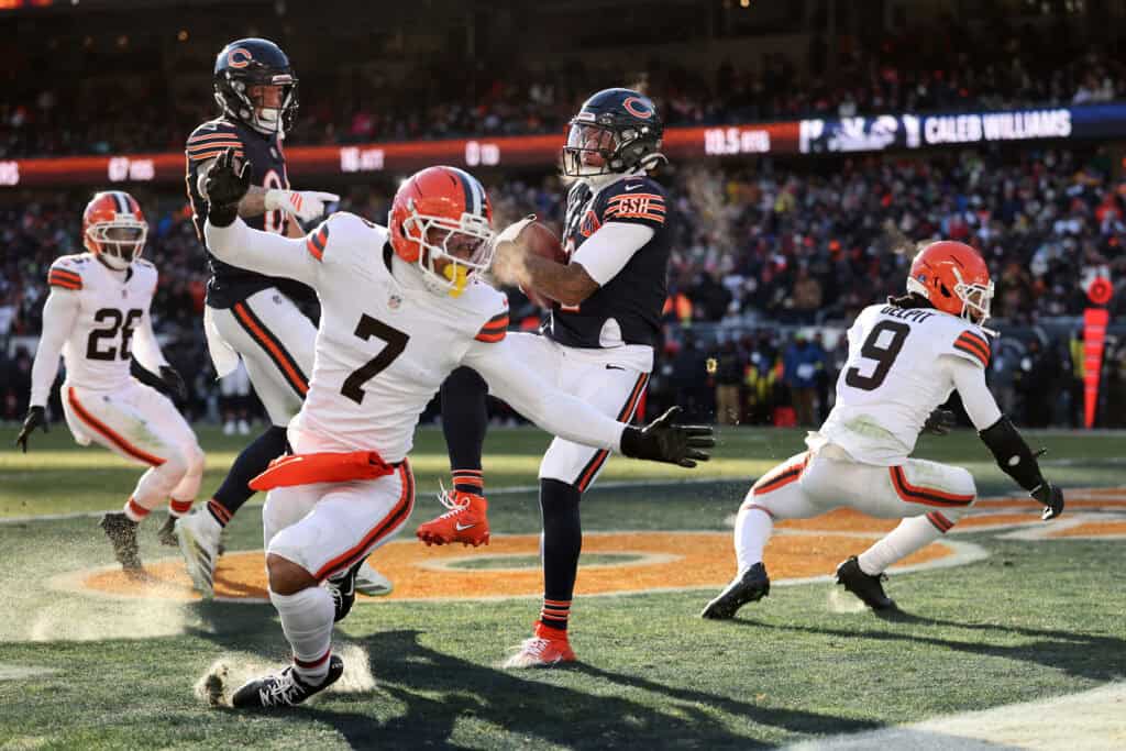 CHICAGO, ILLINOIS - DECEMBER 14: D'Marco Jackson #48 of the Chicago Bears pulls down an interception over Grant Delpit #9 and Tyson Campbell #7 of the Cleveland Browns during the third quarter at Soldier Field on December 14, 2025 in Chicago, Illinois.