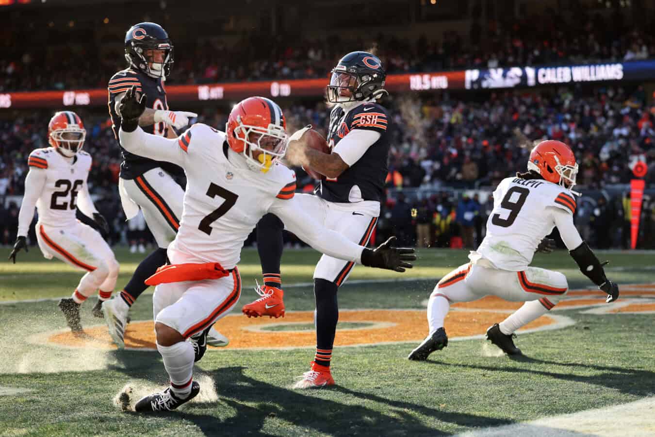 CHICAGO, ILLINOIS - DECEMBER 14: D'Marco Jackson #48 of the Chicago Bears pulls down an interception over Grant Delpit #9 and Tyson Campbell #7 of the Cleveland Browns during the third quarter at Soldier Field on December 14, 2025 in Chicago, Illinois.