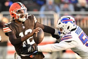 CLEVELAND, OHIO - DECEMBER 21: Shedeur Sanders #12 of the Cleveland Browns is tackled by Greg Rousseau #50 of the Buffalo Bills for a safety in the fourth quarter of the game at Huntington Bank Field on December 21, 2025 in Cleveland, Ohio.