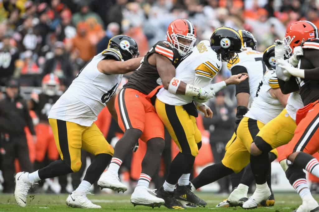 CLEVELAND, OHIO - DECEMBER 28: Myles Garrett #95 of the Cleveland Browns tackles Aaron Rodgers #8 of the Pittsburgh Steelers after a pass during the second quarter at Huntington Bank Field on December 28, 2025 in Cleveland, Ohio.