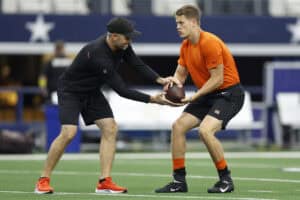 ARLINGTON, TEXAS - SEPTEMBER 18: Joe Burrow #9 of the Cincinnati Bengals runs warmup drills with quarterbacks coach Dan Pitcher before the game against the Dallas Cowboys at AT&T Stadium on September 18, 2022 in Arlington, Texas.