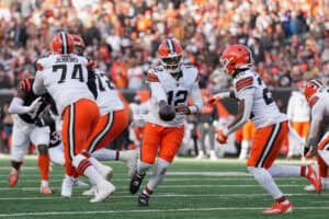 CINCINNATI, OHIO - JANUARY 04: Shedeur Sanders #12 of the Cleveland Browns hands off to teammate Dylan Sampson #22 during the third quarter of the game against the Cincinnati Bengals at Paycor Stadium on January 04, 2026 in Cincinnati, Ohio.