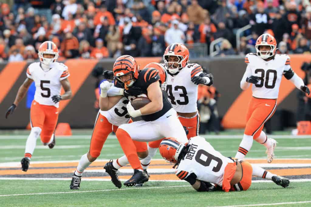 CINCINNATI, OHIO - JANUARY 04: Drew Sample #89 of the Cincinnati Bengals is tackled by Ronnie Hickman #33, Mohamoud Diabate #43 and Grant Delpit #9 of the Cleveland Browns during the third quarter of the game at Paycor Stadium on January 04, 2026 in Cincinnati, Ohio.