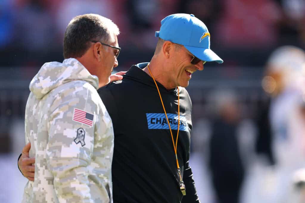 CLEVELAND, OHIO - NOVEMBER 03: Defensive coordinator Jim Schwartz of the Cleveland Browns talks to head coach Jim Harbaugh of the Los Angeles Chargers prior to a game at Huntington Bank Field on November 03, 2024 in Cleveland, Ohio.