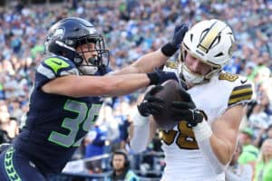 SEATTLE, WASHINGTON - SEPTEMBER 21: Jack Stoll #88 of the New Orleans Saints catches a touchdown pass defended by Ty Okada #39 of the Seattle Seahawks during the fourth quarter at Lumen Field on September 21, 2025 in Seattle, Washington.